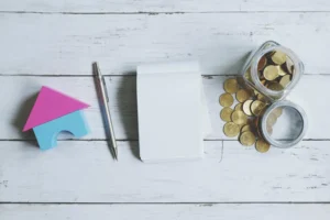 Calculadora y monedas junto a una foto familiar, representando el cálculo de la pensión alimenticia en Uruguay.